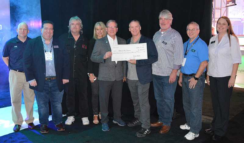 David Lincecum, vice president of marketing for ETC presents a cheque to Behind the Scene Foundation chair Rick Rudolph, joined by ETC staff and members of the Behind the Scenes Foundation Board of Directors