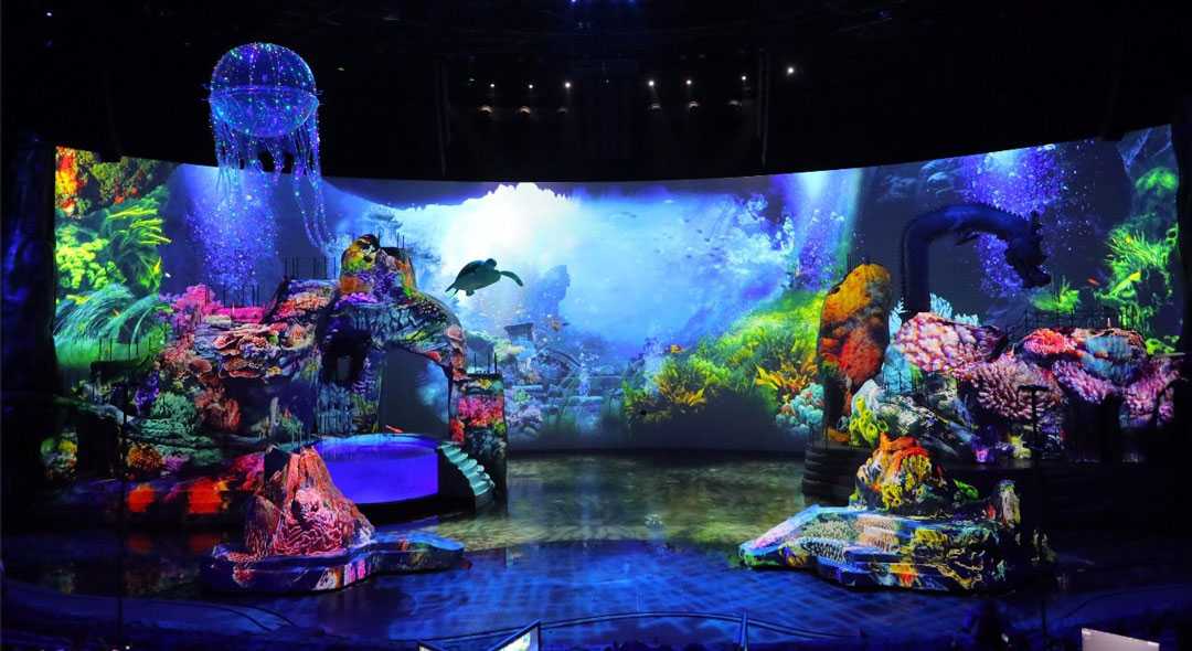 The scene fluctuates between land and sea throughout the performance