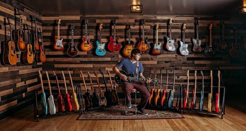 Dillon Taylor with his guitar collection at Dillon's Garage