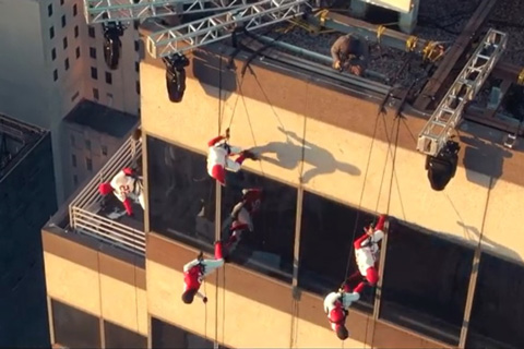 A vertical dance troupe performed across the façade of the building